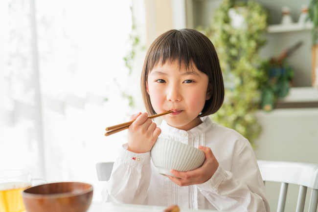 una bambina giapponese che mangia riso